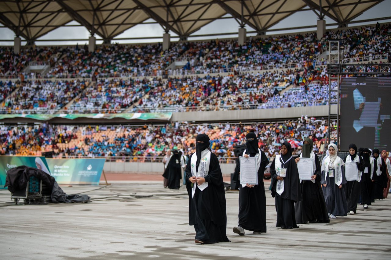‏أكثر من ستين ألفاً من الحضور في مشهد قرآنيّ فريد، أبطالُه فتياتٌ حَمَلْنَ القرآنَ الكريم في صدورهنَّ، وتَوافَدْنَ مِن مختلف أنحاء العالم. ‏الحدثُ بمُبادرةٍ من ⁧‫رابطة العالم الإسلامي‬⁩ وجمهورية تنزانيا